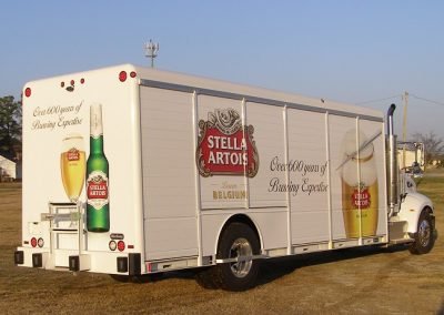 Commercial Truck Wrap of a large Stella beer delivery truck pictured on a grassfield.
