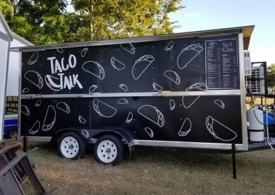 Street side of "Taco Talk" Food Truck Wrap displaying logo, stylized tacos and menu..