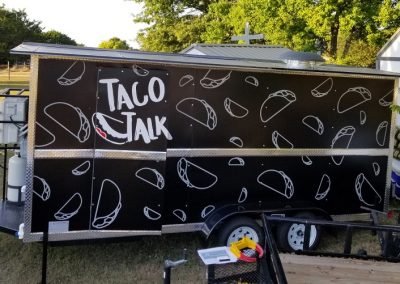 Side view of a food Vehicle Wrap with Taco Talk logo and stylized taco figures.