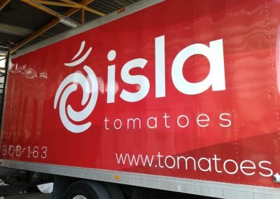 Close-up of a dry box Truck Wrap with Isla Tomatoes logo and information on red background.